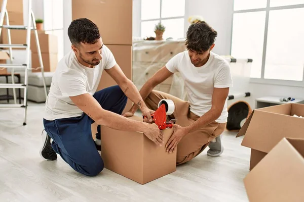 Two Hispanic Men Couple Smiling Confident Packing Cardboard Box New — Stock Photo, Image