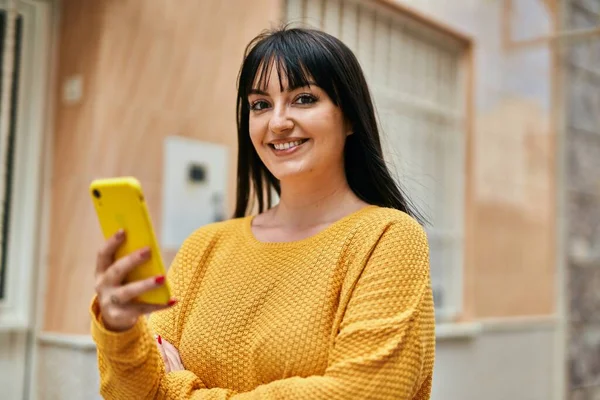在城市里 年轻的黑发女人用智能手机开心地微笑 — 图库照片