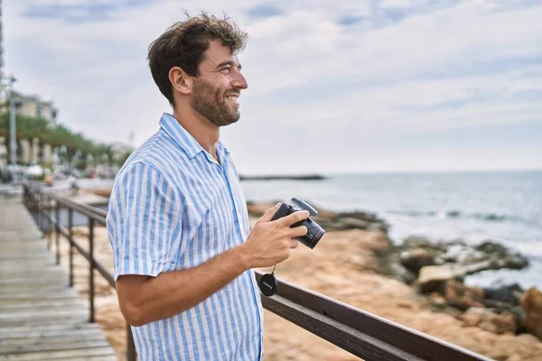 Ung Latinamerikansk Man Ler Glad Med Kameran Stranden — Stockfoto