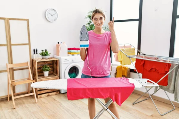 Young Blonde Woman Ironing Clothes Home Surprised Idea Question Pointing — Stock Photo, Image