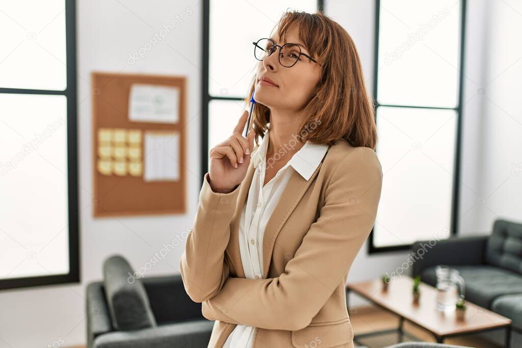 Young caucasian businesswoman with doubt expression and arms crossed gesture at the office.