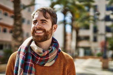 Güneşli bir günde, açık havada sakallı, beyaz bir genç.