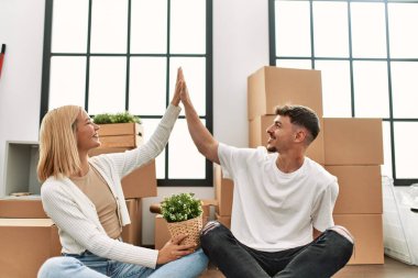 Genç beyaz çift gülümsüyor mutlu beşlikler yeni evlerinde oturuyor.