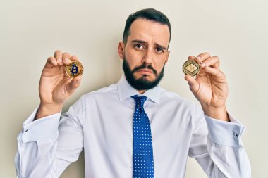 Sakallı genç adam elinde sanal para ve bitcoin tutuyordu. Depresyondaydı ve sıkıntıdan endişe ediyordu. Öfkeli ve korkmuştu. hüzünlü ifade. 