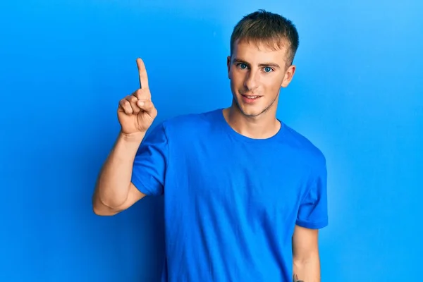 Junger Kaukasischer Mann Lässigem Blauem Shirt Mit Erhobenem Zeigefinger Und — Stockfoto