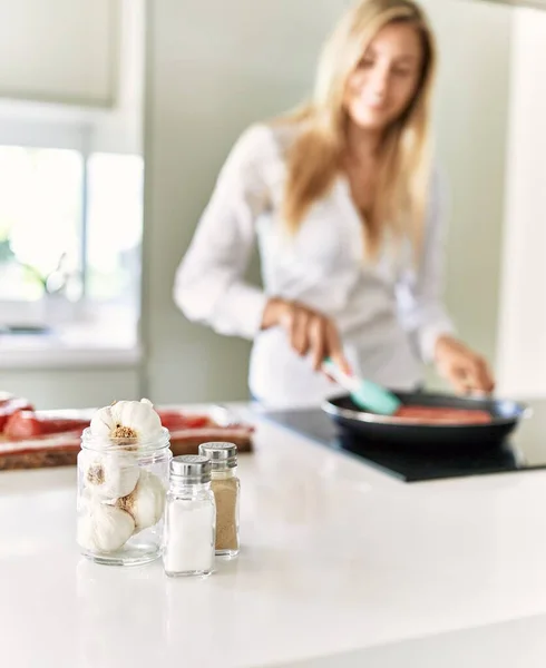 Genç Sarışın Kadın Mutfakta Kendine Güvenen Bir Biftek Pişiriyor — Stok fotoğraf