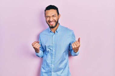 Sıradan mavi tişörtlü İspanyol adam kolları havada ve gözleri kapalı zaferi kutlarken heyecanla bekliyor. Kazanan konsept. 