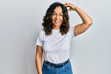 Sıradan beyaz tişört giyen orta yaşlı İspanyol kadın soru sorup kafasını karıştırıyor. Şüpheyle kararsız, kafa kafaya düşünerek. Düşünceli kavram. 