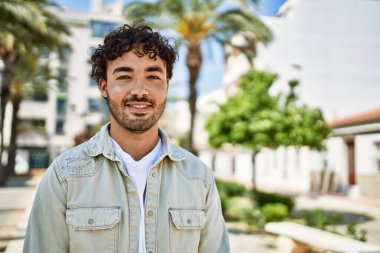 Yakışıklı, sakallı, güneşli bir günde mutlu bir şekilde gülümseyen bir İspanyol.