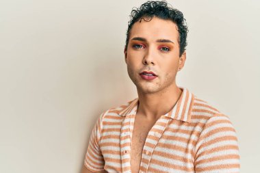 Makyaj yapan yakışıklı, sıradan bir gömlek giyen, gülümseyen, mutlu, eli ve parmağı olan bir adam. 