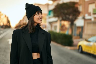 Genç İspanyol kadın gülümseyerek şehirde mutlu mesut dikiliyor..