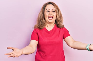 Orta yaşlı, günlük kıyafetler giyen, neşeli gülümseyen, yardım eli uzatan ve kabul gören beyaz bir kadın.. 