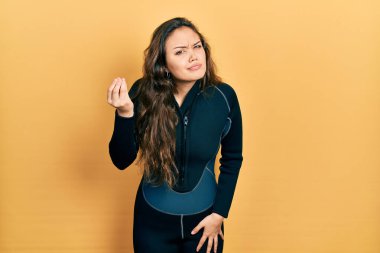Genç İspanyol kız dalgıç neoprene üniforması giyiyor. İtalyan jesti yapıyor. Elleri ve parmakları kendinden emin. 