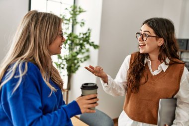 İki iş kadını kahve içip ofiste konuşarak rahatladı..