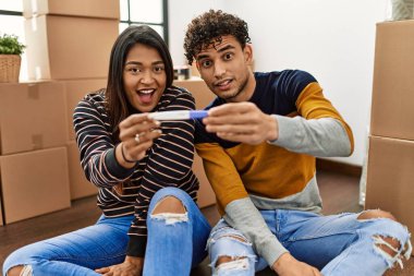 Genç Latin çift yeni evlerinde yerde otururken hamilelik testi yaparken şaşırdılar..