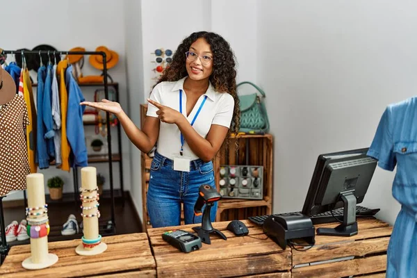 Elbise mağazasında çalışan güzel İspanyol kadın kameraya hayret içinde bakıp gülümserken eliyle ve parmağıyla işaret ediyordu.. 