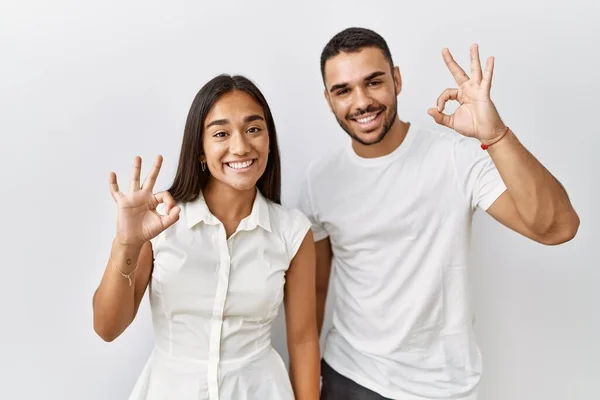 若い異人種間のカップル一緒に愛の中で孤立した背景に肯定的な手と指でOkのサインをやって笑顔立っている 成功した表現 — ストック写真