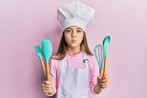 Vacker Brunett Liten Flicka Bär Professionell Kock Förkläde Hålla Matlagningsverktyg — Stockfoto