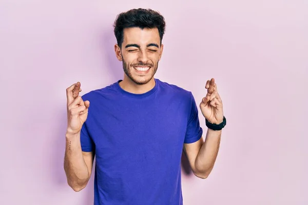 Mladý Hispánec Nenucené Košili Prstem Zkříženým Nadějí Zavřenýma Očima Usmál — Stock fotografie