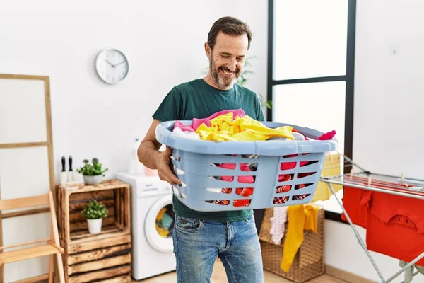 Medelålders Latinamerikan Gör Tvätt Hålla Korg Med Kläder Hemma — Stockfoto