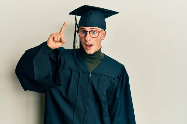 Young Caucasian Man Wearing Graduation Cap Ceremony Robe Pointing Finger — Stock Photo, Image