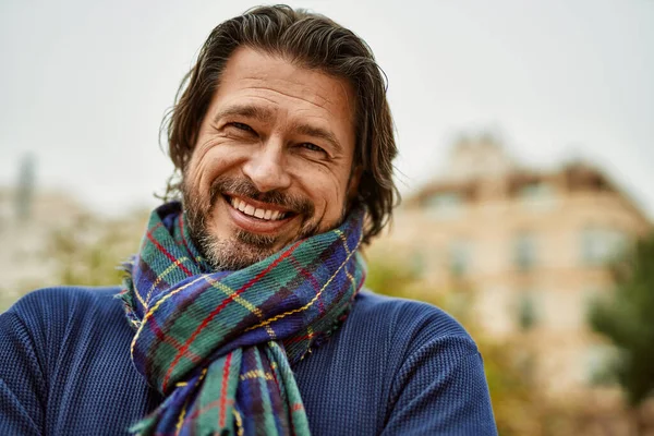 Kasabada gülümseyen orta yaşlı yakışıklı bir adam.