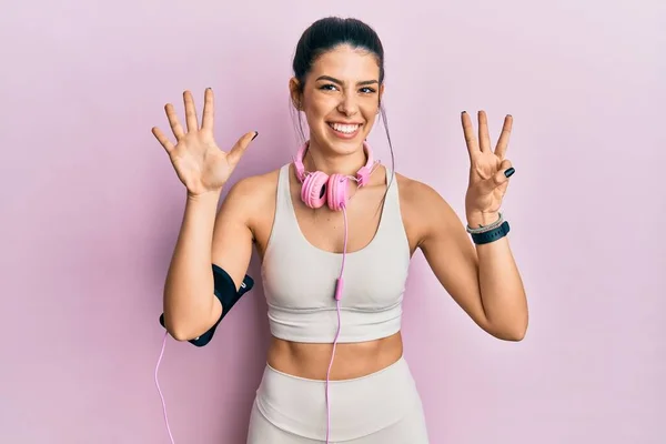 Young Hispanic Woman Wearing Gym Clothes Using Headphones Showing Pointing — Stock Photo, Image