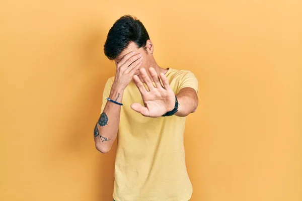 Νεαρός Ισπανόφωνος Άνδρας Φοράει Casual Κίτρινο Shirt Καλύπτοντας Μάτια Χέρια — Φωτογραφία Αρχείου
