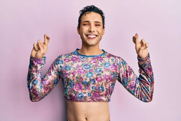 Makyaj elbisesi giyen yakışıklı adam umut ve gözlerin kapalı gülümseyerek el işareti yapıyor. Şans ve batıl inançlar. 