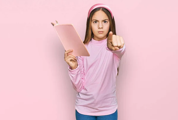 Hermosa Niña Morena Leyendo Libro Señalando Con Dedo Cámara Gesto —  Fotos de Stock