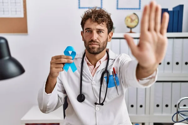 Mladý Hispánský Lékař Muž Drží Modrou Stuhu Otevřenou Rukou Dělá — Stock fotografie