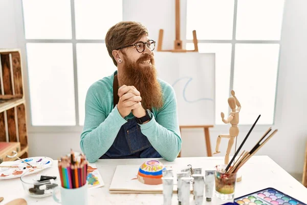 红头发的男人留着长胡子 在艺术工作室里画着黏土碗 面带微笑地看着旁边 自然的表情 充满自信地大笑 — 图库照片