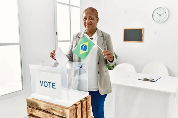 Senior Afrikansk Amerikansk Kvinde Holder Brasilien Flag Stemme Ved Valg - Stock-foto