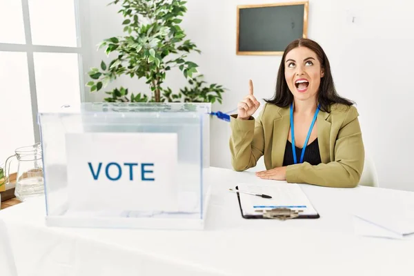 Young Brunette Woman Sitting Election Table Voting Ballot Pointing Finger — Stock Photo, Image