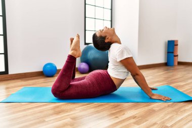 Genç İspanyol kadın gülümsüyor spor merkezinde esniyor.