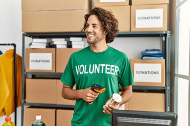 Yardım merkezinde çalışırken gülümseyen Latin asıllı gönüllü adam..