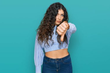 Gündelik kıyafetler giyen genç İspanyol kız mutsuz görünüyor ve reddediliyor ve olumsuz bir hareket yapıyor. kötü ifade. 