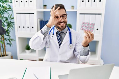 Yakışıklı İspanyol üniformalı, elinde reçeteli haplarla mutlu mesut gülümsüyor. 