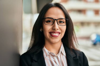 Genç İspanyol iş kadını şehirde mutlu mesut ayakta duruyor..