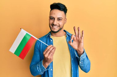 Genç Arap adam elinde Bulgar bayrağı tutuyor. Parmaklarıyla imza atıyor, gülümsüyor. Mükemmel bir sembol. 