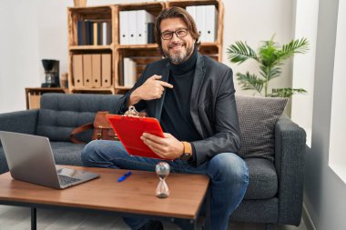 Muayenehanede çalışan yakışıklı, kendine güveni tam, kendini gururlu ve mutlu gösteren orta yaşlı bir adam.. 