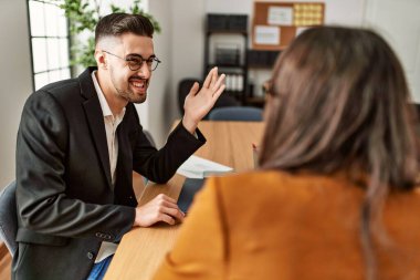 Ofiste çalışırken gülümseyen iki İspanyol iş adamı..