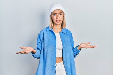 Güzel sarışın kadın, yün şapka takıyor, habersiz ve kolları açık, hiçbir fikri yok.. 