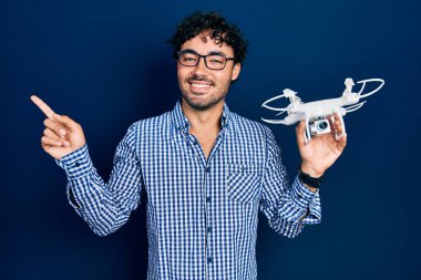 İHA 'yı tutan genç İspanyol adam gülümsüyor. 