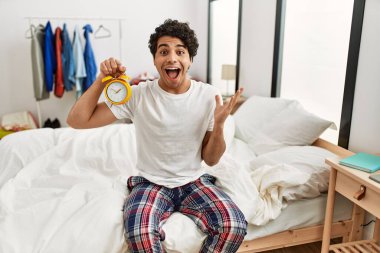 Çalar saati tutan İspanyol genç adam zaferi mutlu bir gülümsemeyle ve ellerini kaldırarak kutluyor. 