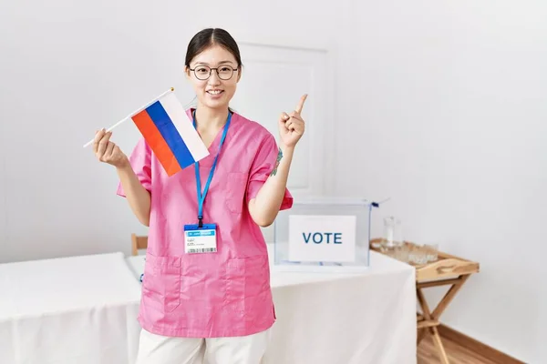 Молодая Женщина Медсестра Азии Выборах Парламент Держит Российский Флаг Улыбаясь — стоковое фото