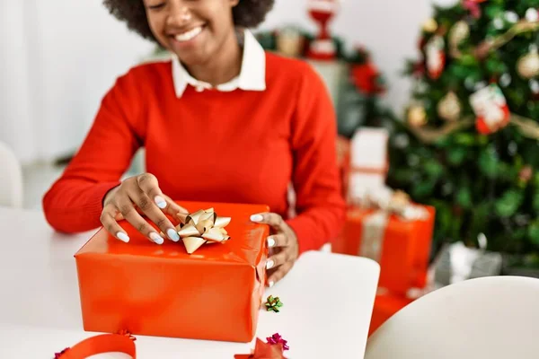 Joven Mujer Afroamericana Sonriendo Confiado Embalaje Regalo Navidad Casa —  Fotos de Stock