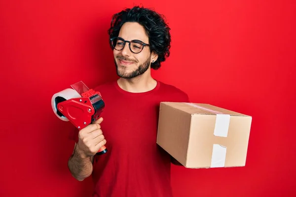 Knappe Spaanse Man Met Pakband Kartonnen Doos Glimlachend Naar Zijkant — Stockfoto