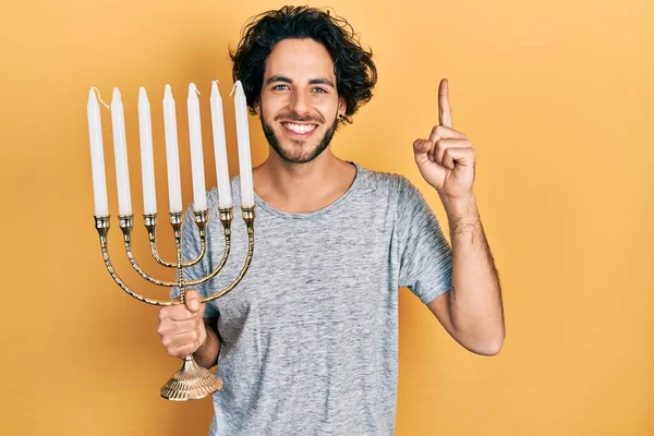 Hombre Hispano Guapo Sosteniendo Menorah Hanukkah Vela Judía Sonriendo Con — Foto de Stock