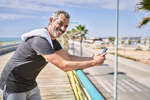 Medelålders Latinamerikansk Man Bär Sportkläder Med Hjälp Smartphone Vid Havet — Stockfoto